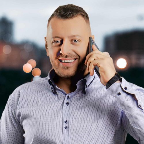 Portret, realitny makler v svetlomodrej koseli s telefonom pri uchu - Gabriel Slavkovsky